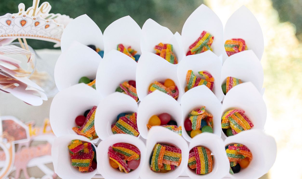 Colorful candy-filled cones arranged outdoors, perfect for a sunny celebration.
