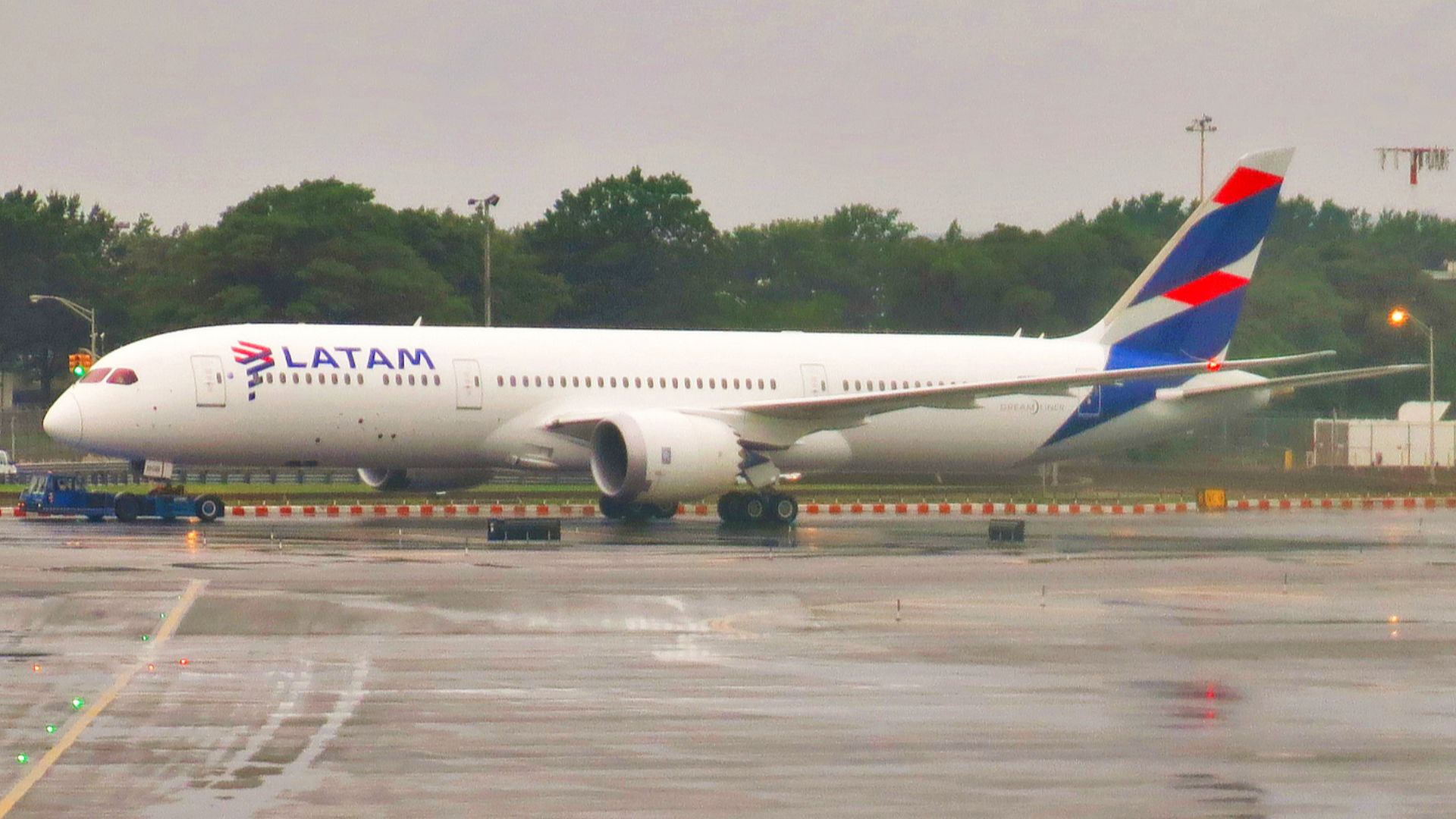 A LATAM Chile Boeing 787-9 Dreamliner is being towed around Terminal 8 at John F. Kennedy International Airport to its gate at Terminal 8 to board passengers for its return flight to Santiago.