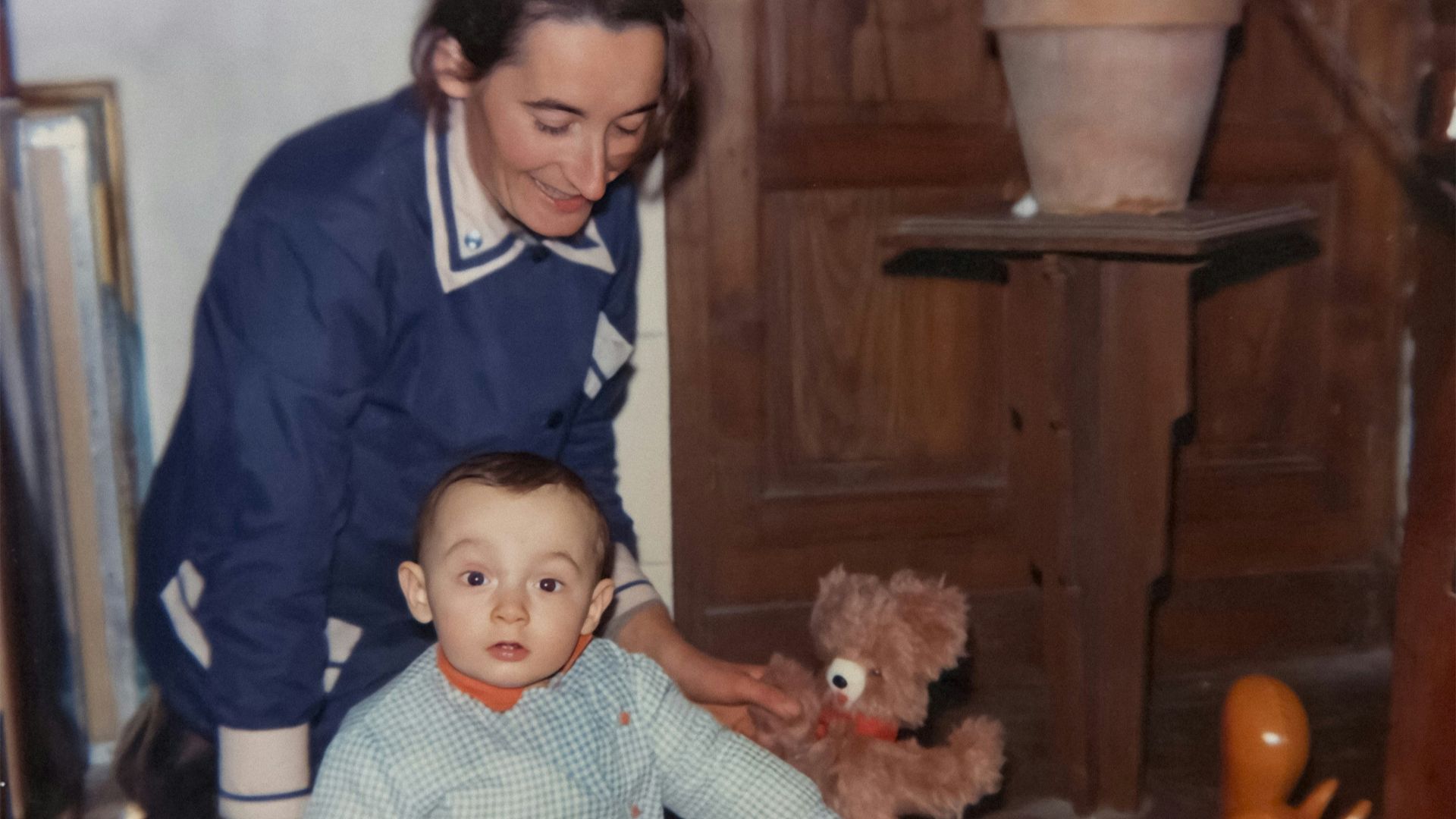Woman and child playing with toys on a wooden floor