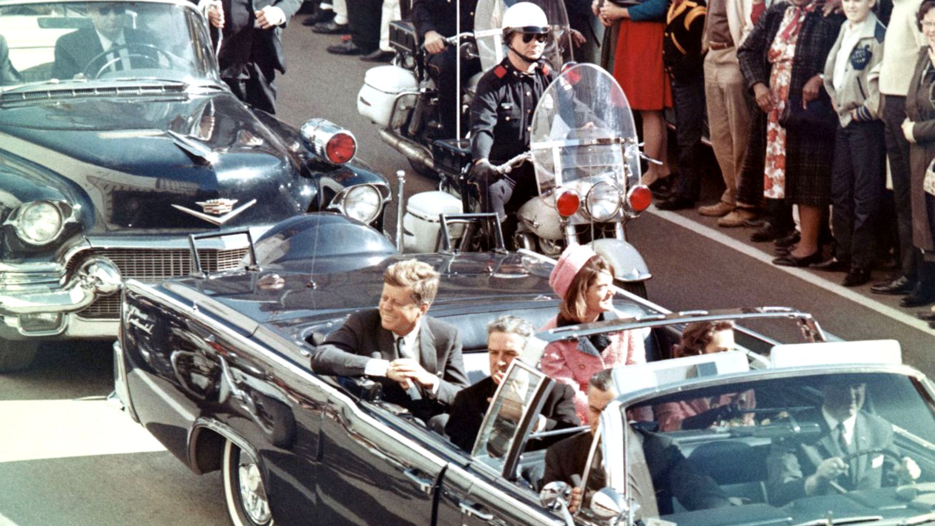 Picture of President Kennedy in the limousine in Dallas, Texas, on Main Street, minutes before the assassination.  Also in the presidential limousine are Jackie Kennedy, Texas Governor John Connally, and his wife, Nellie.