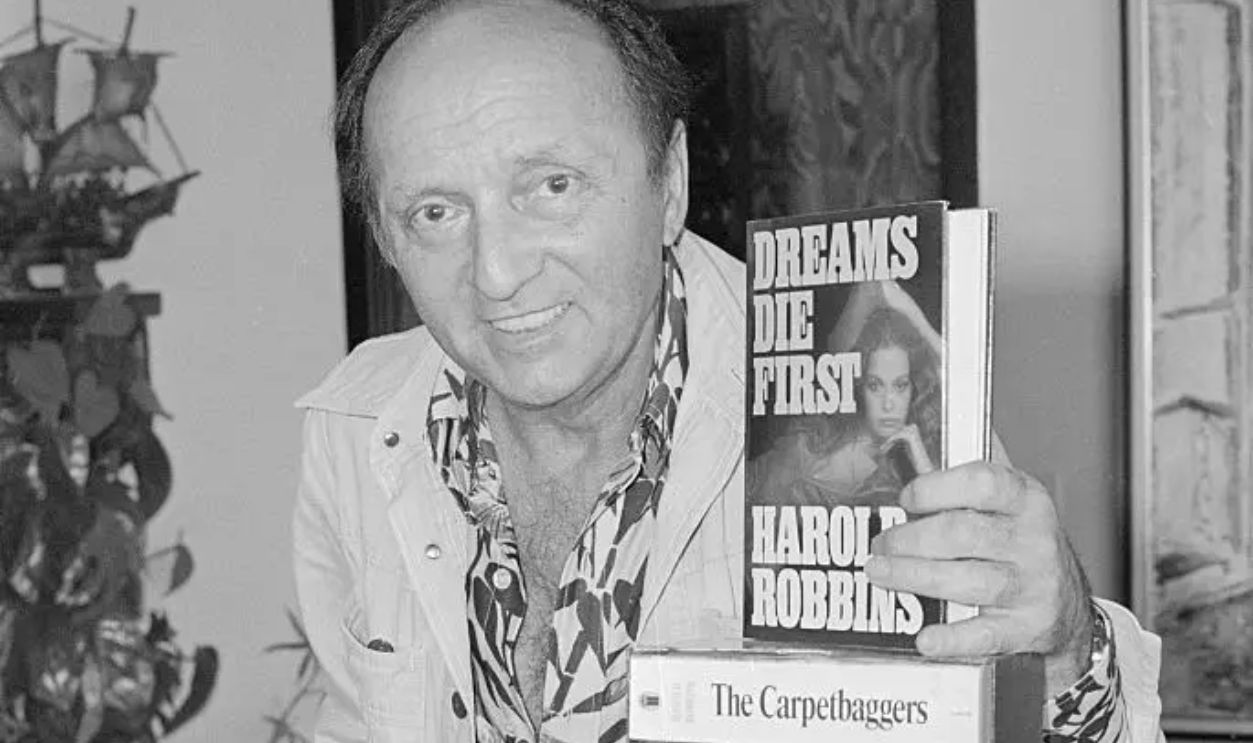 (Original Caption) No living author comes close to Harold Robbins in the staggering total of 200 million books sold. Robbins, 61, was in Washington recently to promote his latest novel, Dreams Die First. He is shown in his Hollywood office in this photograph.