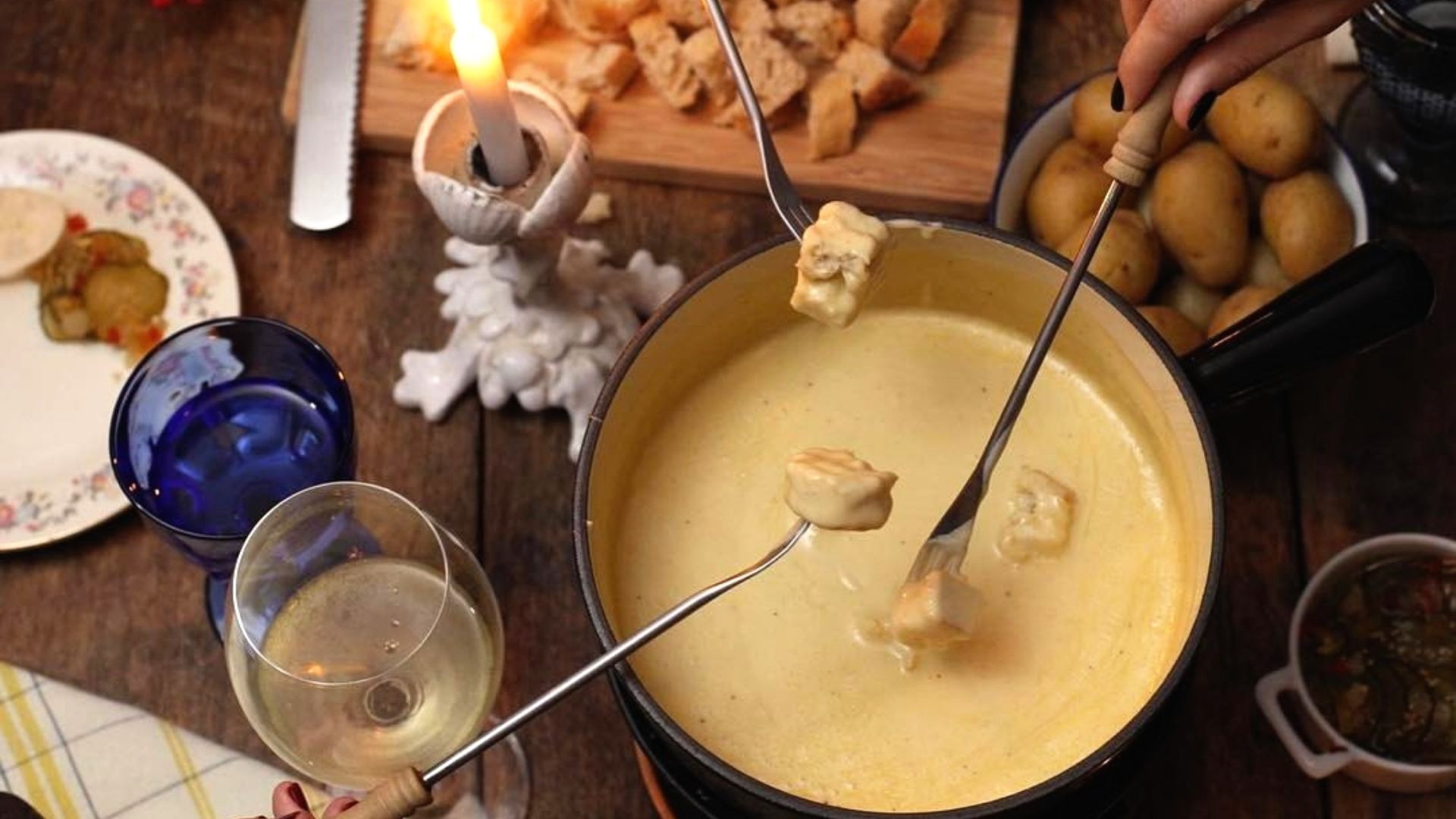 Fondue with Kräuterkäse from Switzerland (herbed cheese) served with bread, potatoes, and white wine