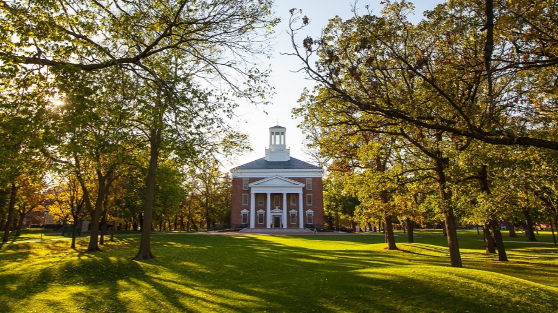 A photo of the sun shining over Middle College on the Beloit College campus.