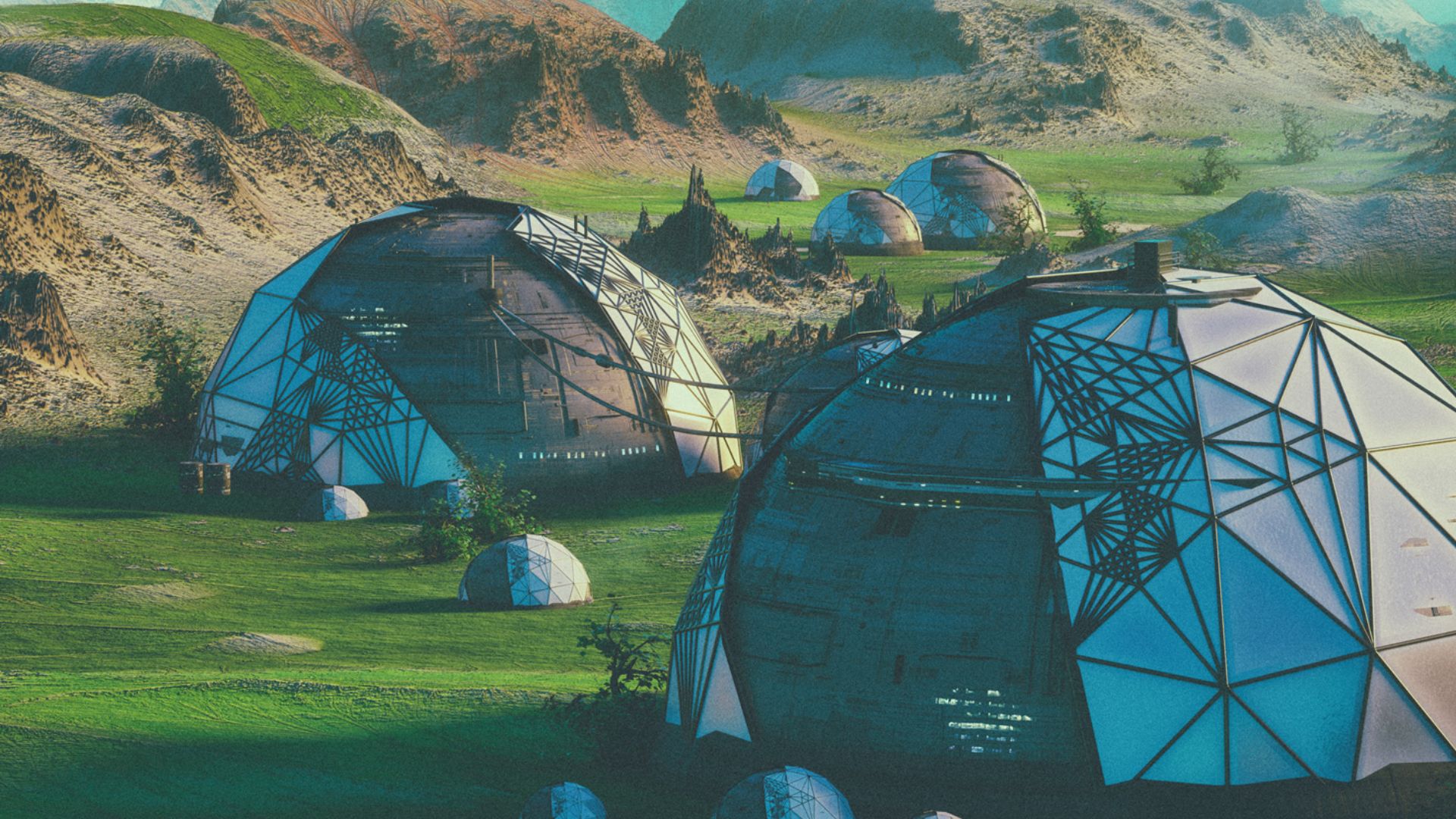 Dome shaped buildings in a green landscape with little vegetation.