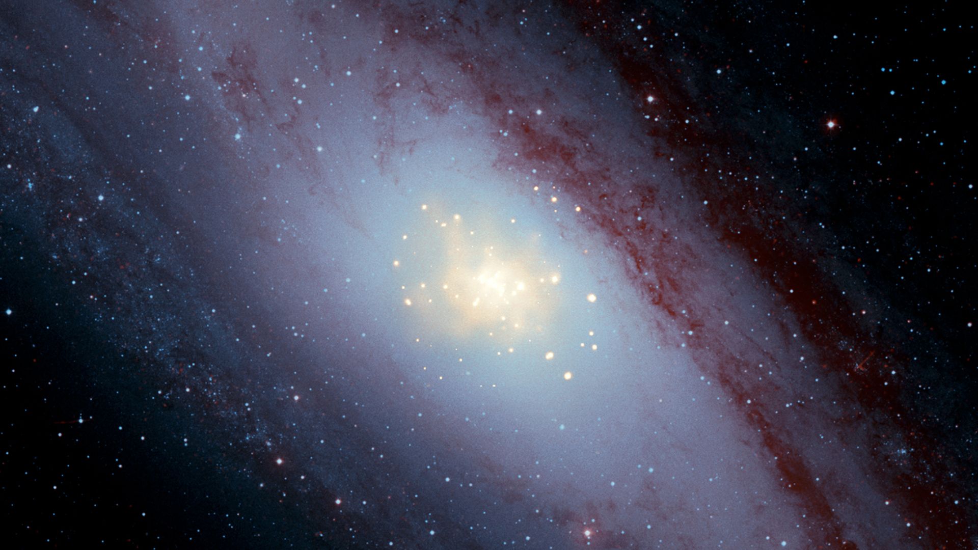 This composite image of M31 (also known as the Andromeda galaxy) shows X-ray data from NASA's Chandra X-ray Observatory in gold, optical data from the Digitized Sky Survey in light blue and infrared data from the Spitzer Space Telescope in red. The Chandr