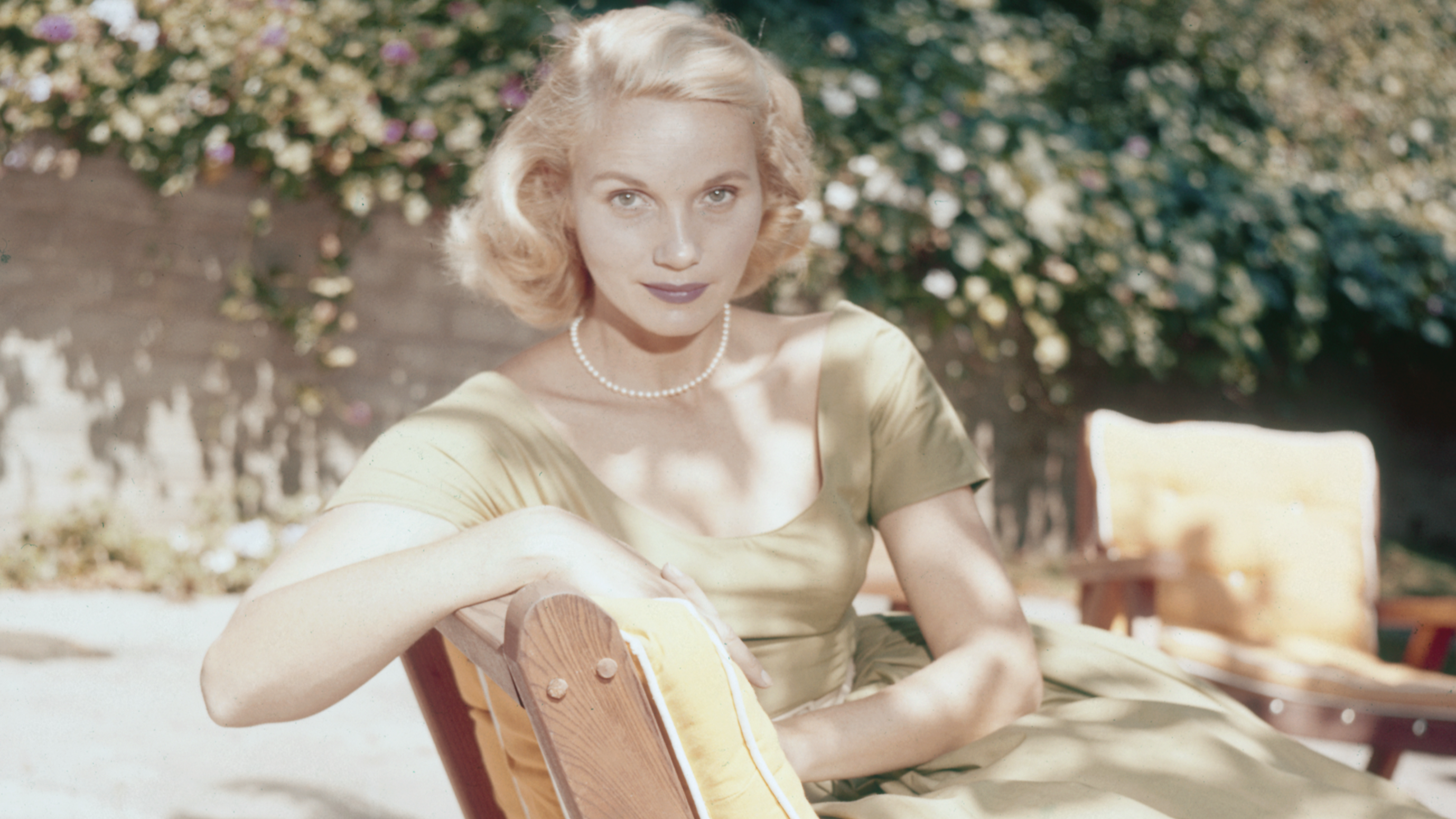 Actress Eva Marie Saint pictured seated on a sun lounger in a garden