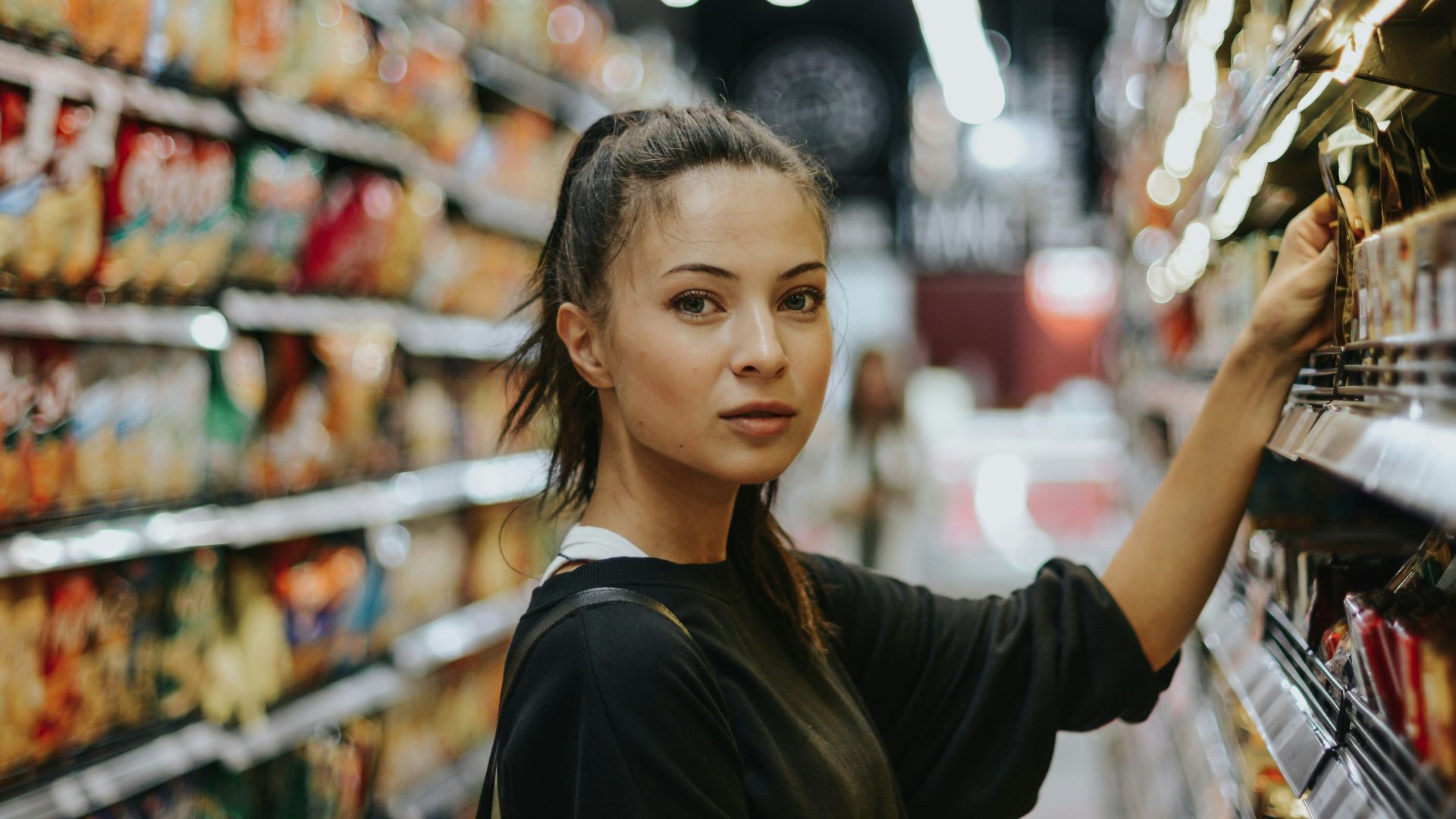 woman selecting packed food on gondola