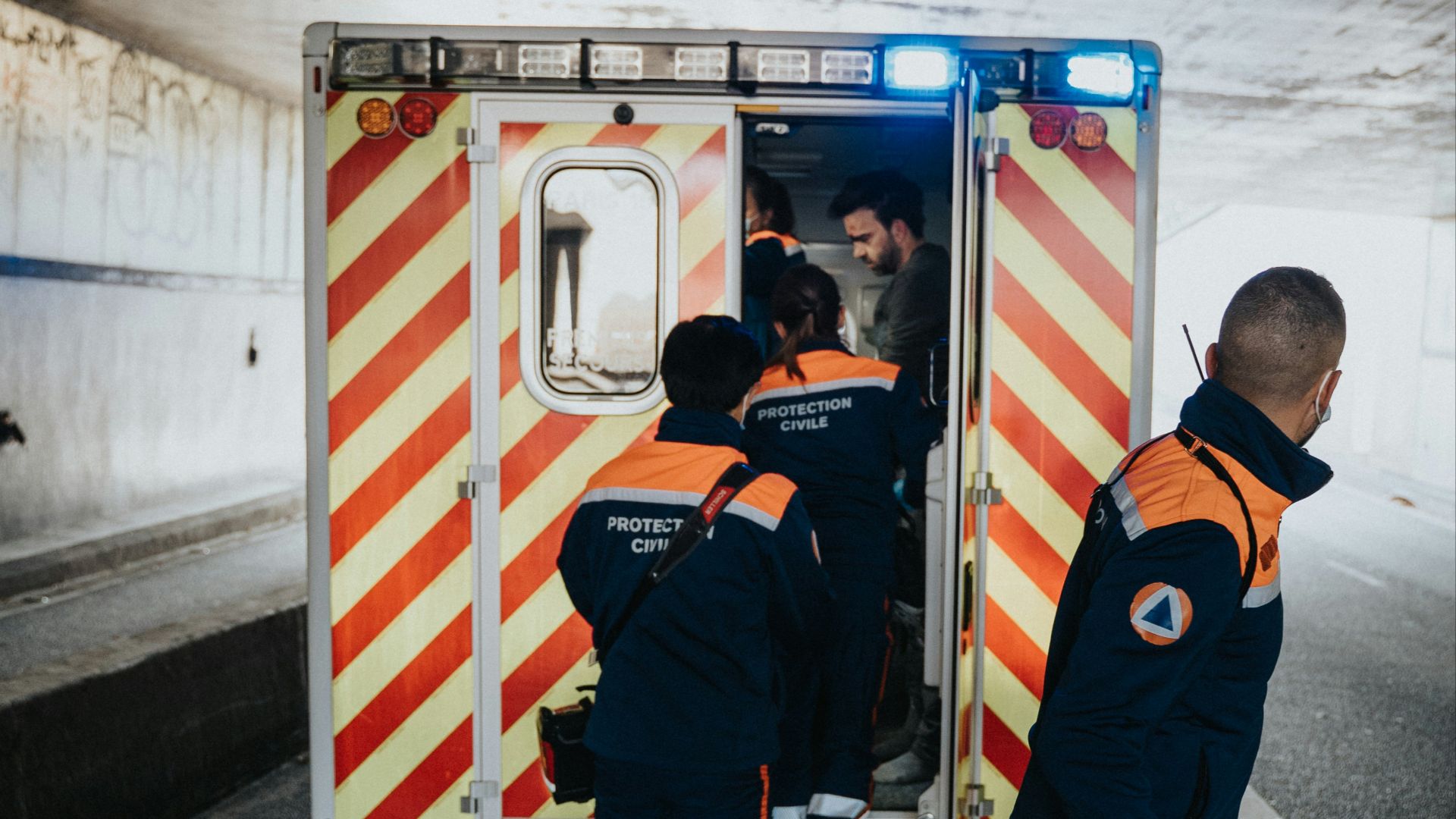 a couple of men standing next to an ambulance