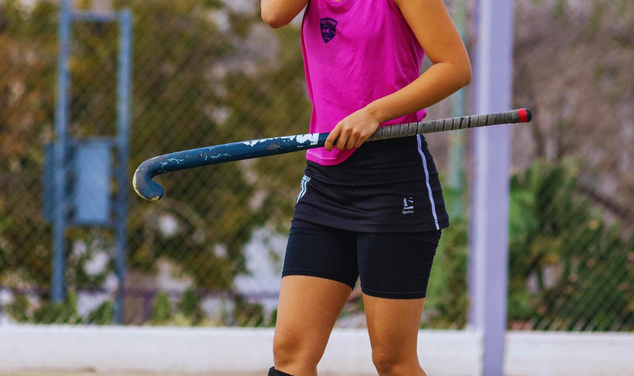 Female Hockey Player in Pink Jersey on Field