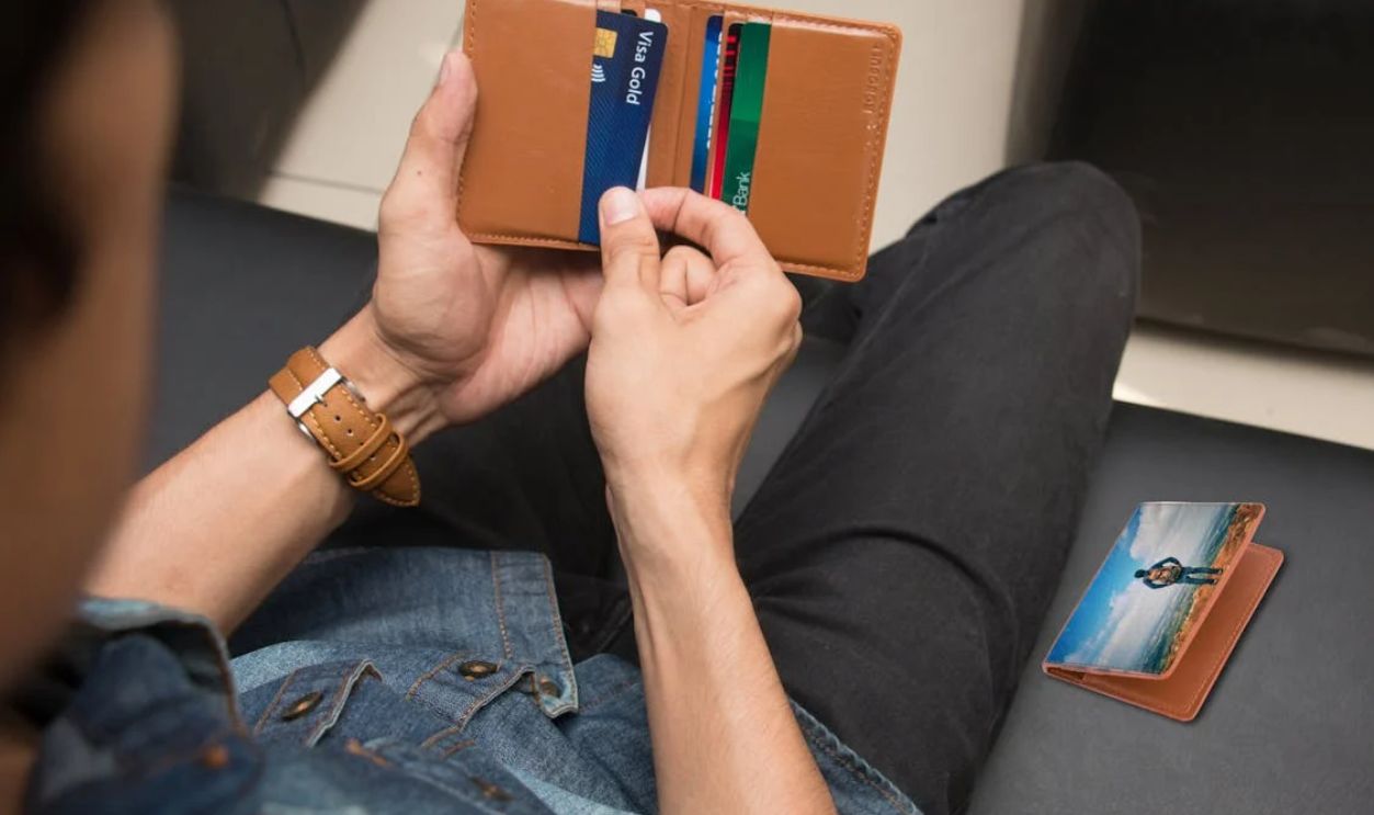 Close-Up Shot of a Person Holding a Brown Wallet with Credit Cards