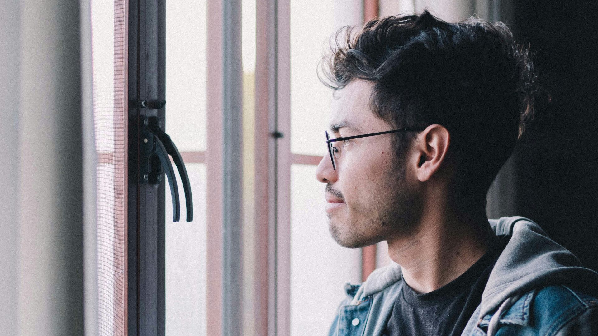 man in blue denim jacket wearing black framed eyeglasses