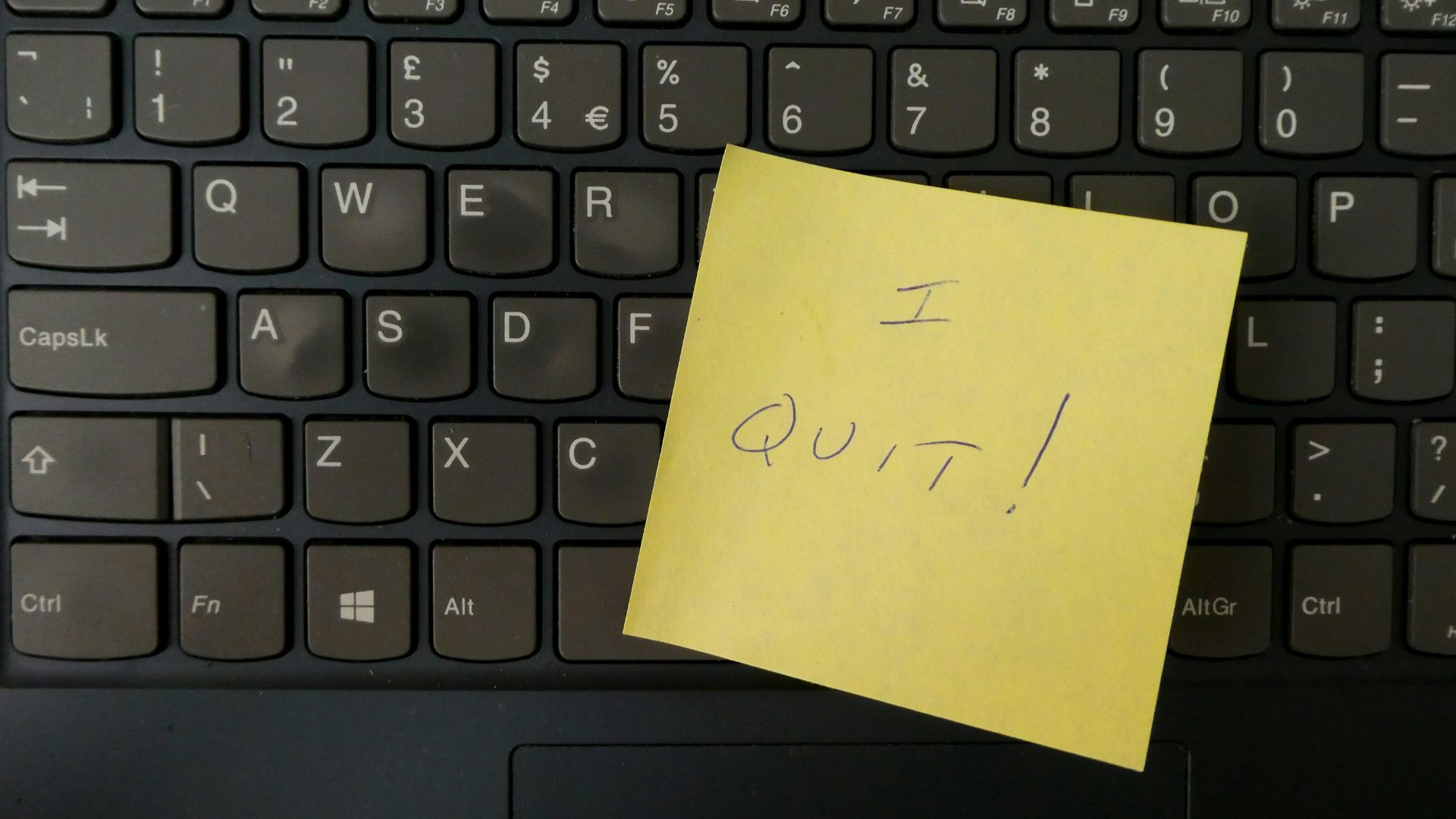 a yellow notepad on a keyboard