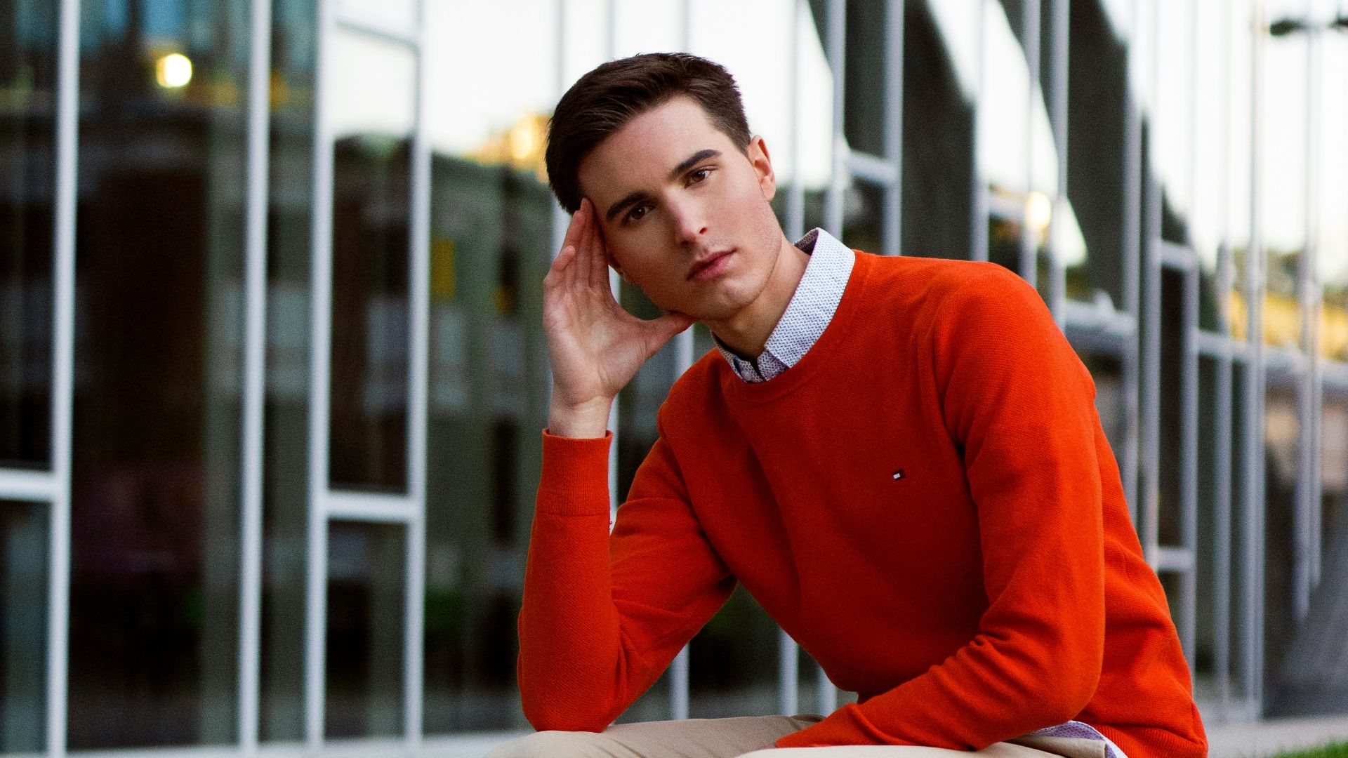 a man sitting on a bench in front of a building