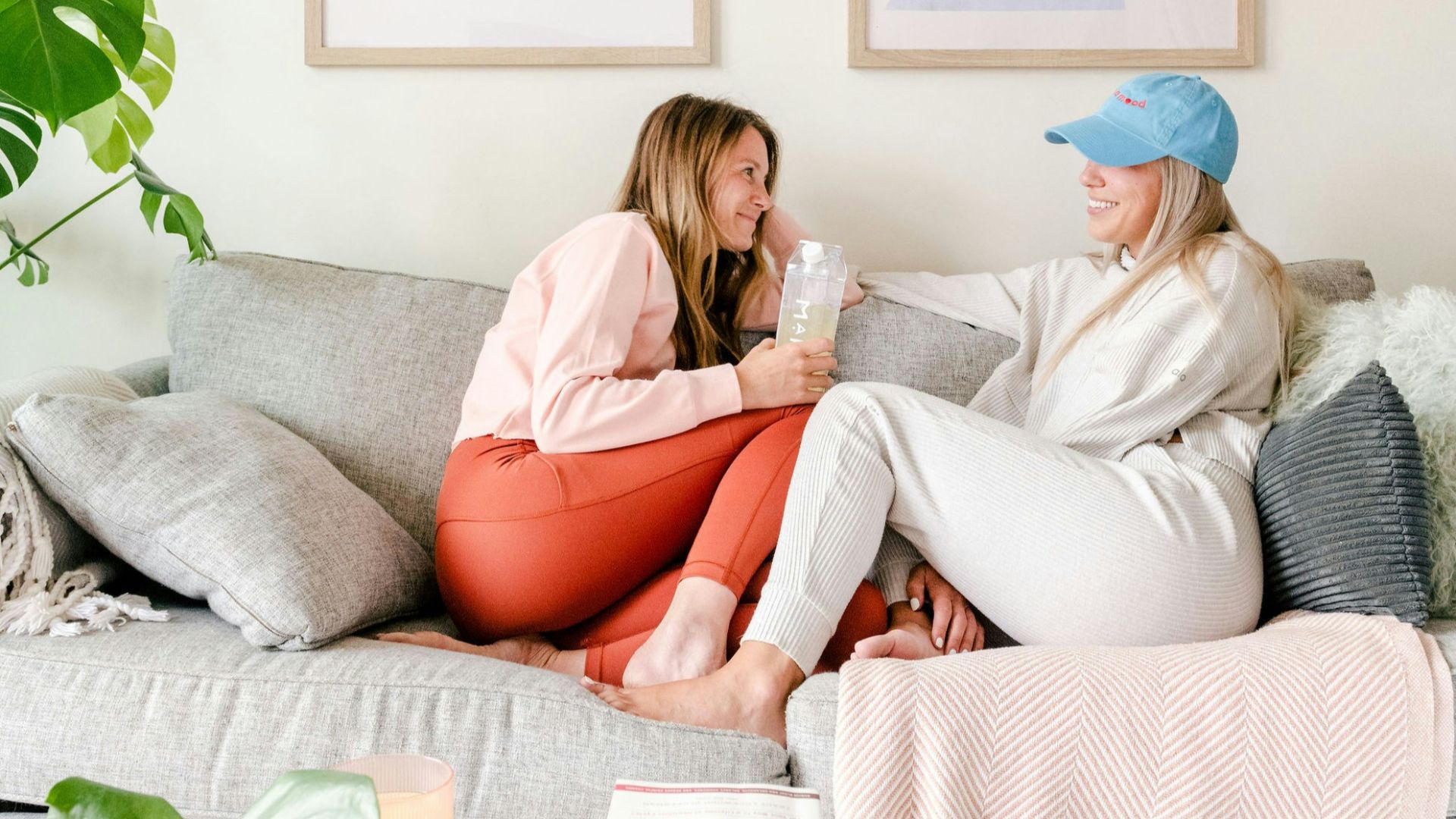 two women sitting on a couch in a living room