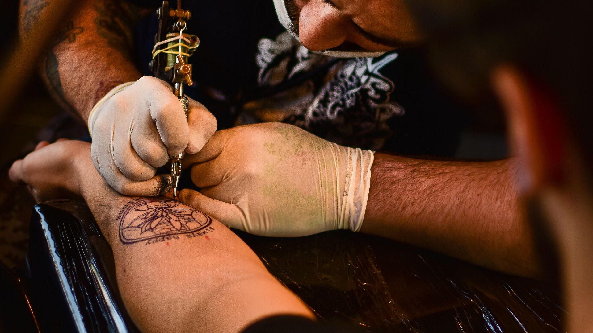 man doing tattoo on human arm