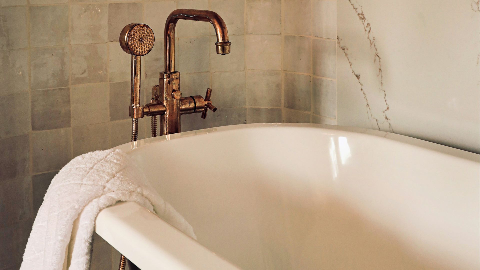 white ceramic bathtub with stainless steel shower head