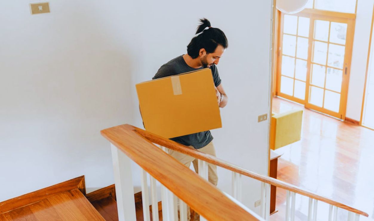 Adult man moving carton box to new house