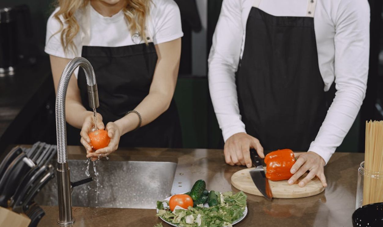 Two People standing beside Kitchen Counter