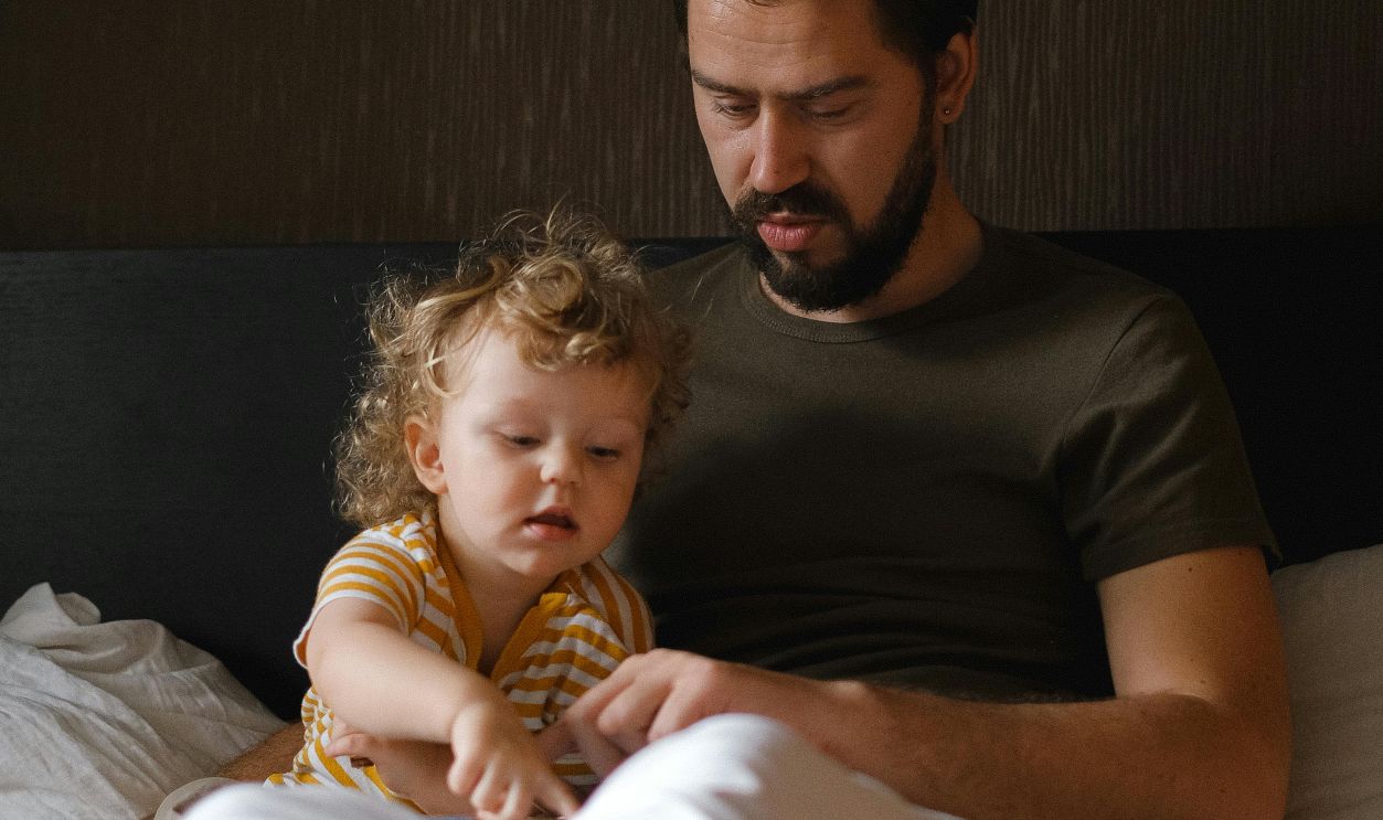 A Man Sitting on the Bed with His Son
