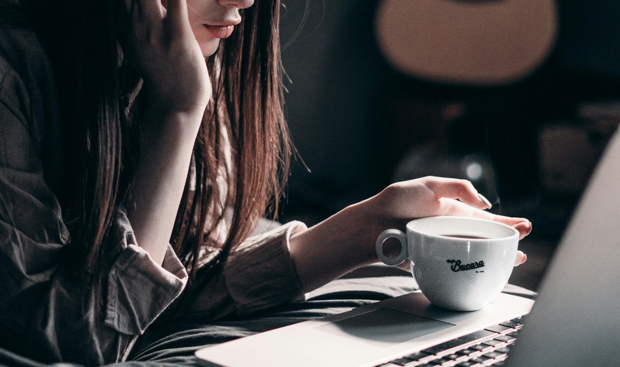 Photo of Woman Lying on Bed While Using Laptop