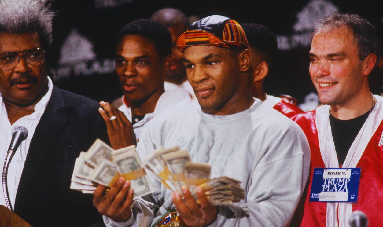 Gettyimages - 52241375, Mike Tyson... UNDATED: Mike Tyson holds two fists full of money and poses for cameras next to Don King during a press conference.