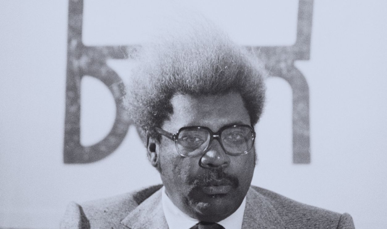 Gettyimages - 1270080846, Don King American boxing promoter Don King in front of his crown logo, 10th July 1986.