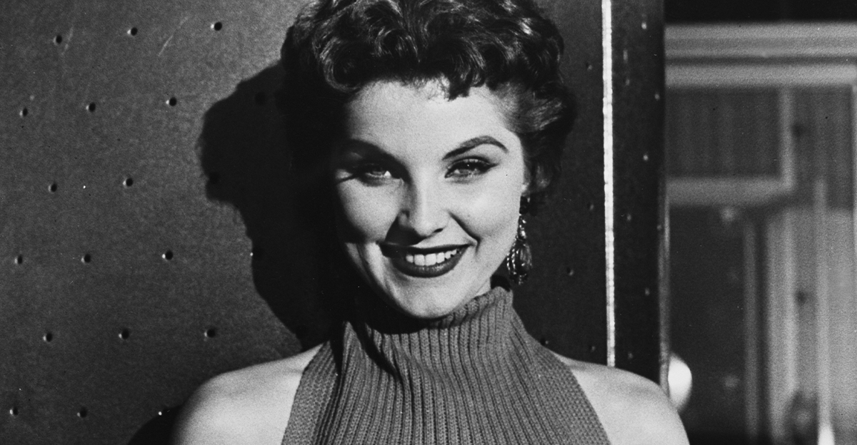 a black and white photograph of Debra Paget, American Actress, smiling at the camera 
