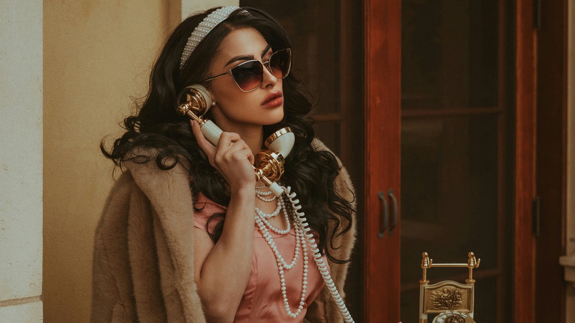 a woman in a pink dress talking on a phone
