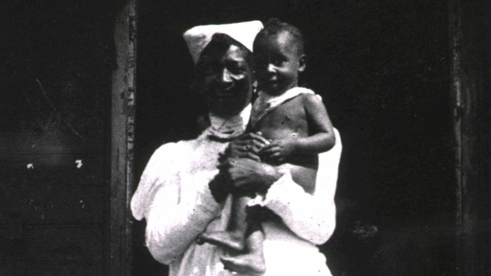 a black and white photo of a woman holding a child