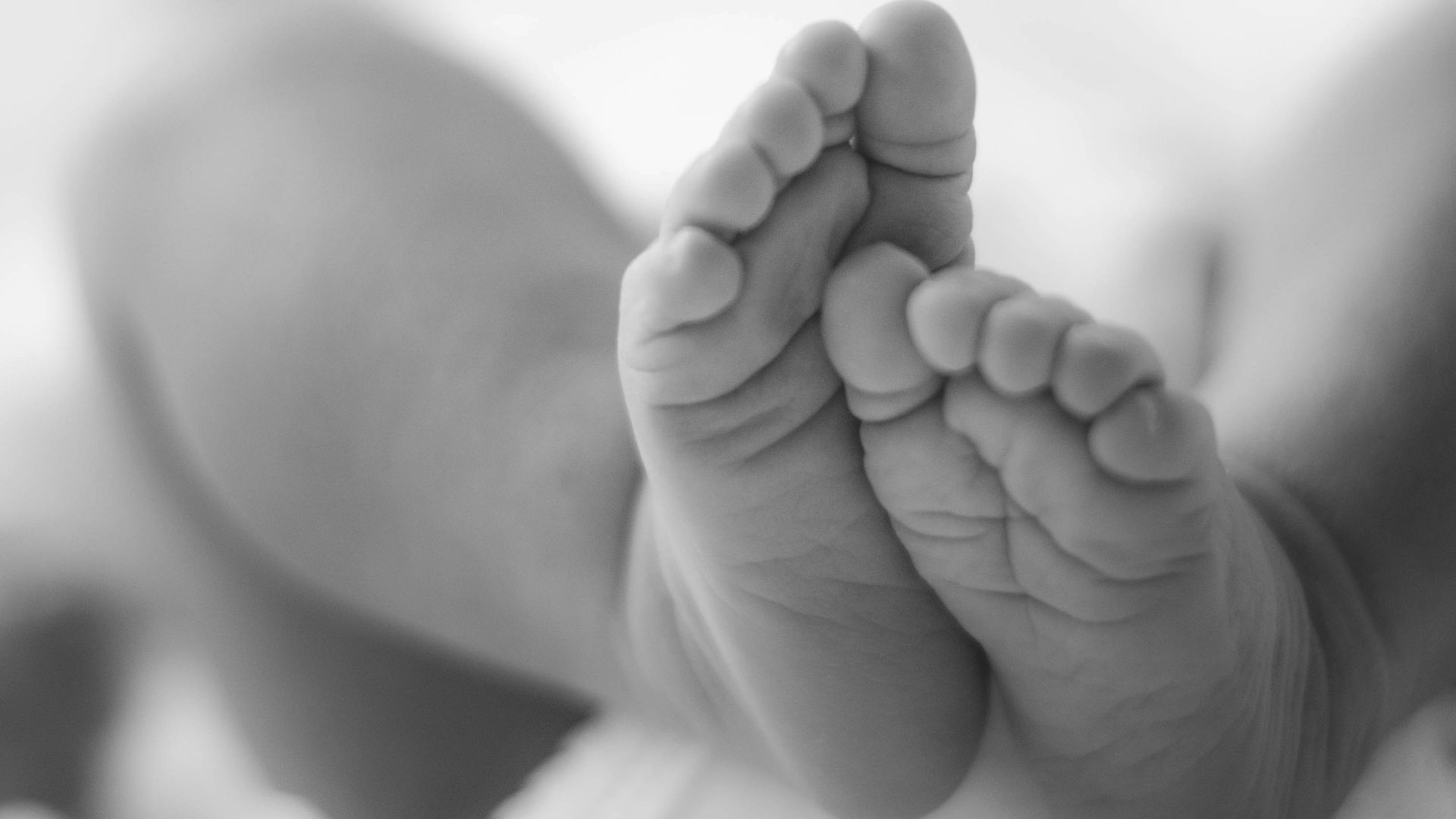 grayscale photo of babys feet