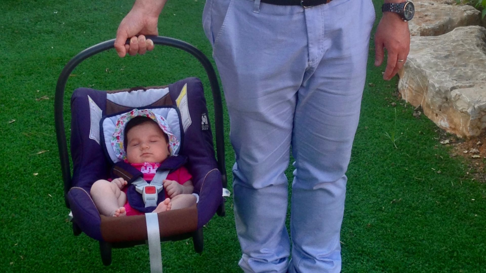 File:A man holding his daughter in a safety seat.jpg