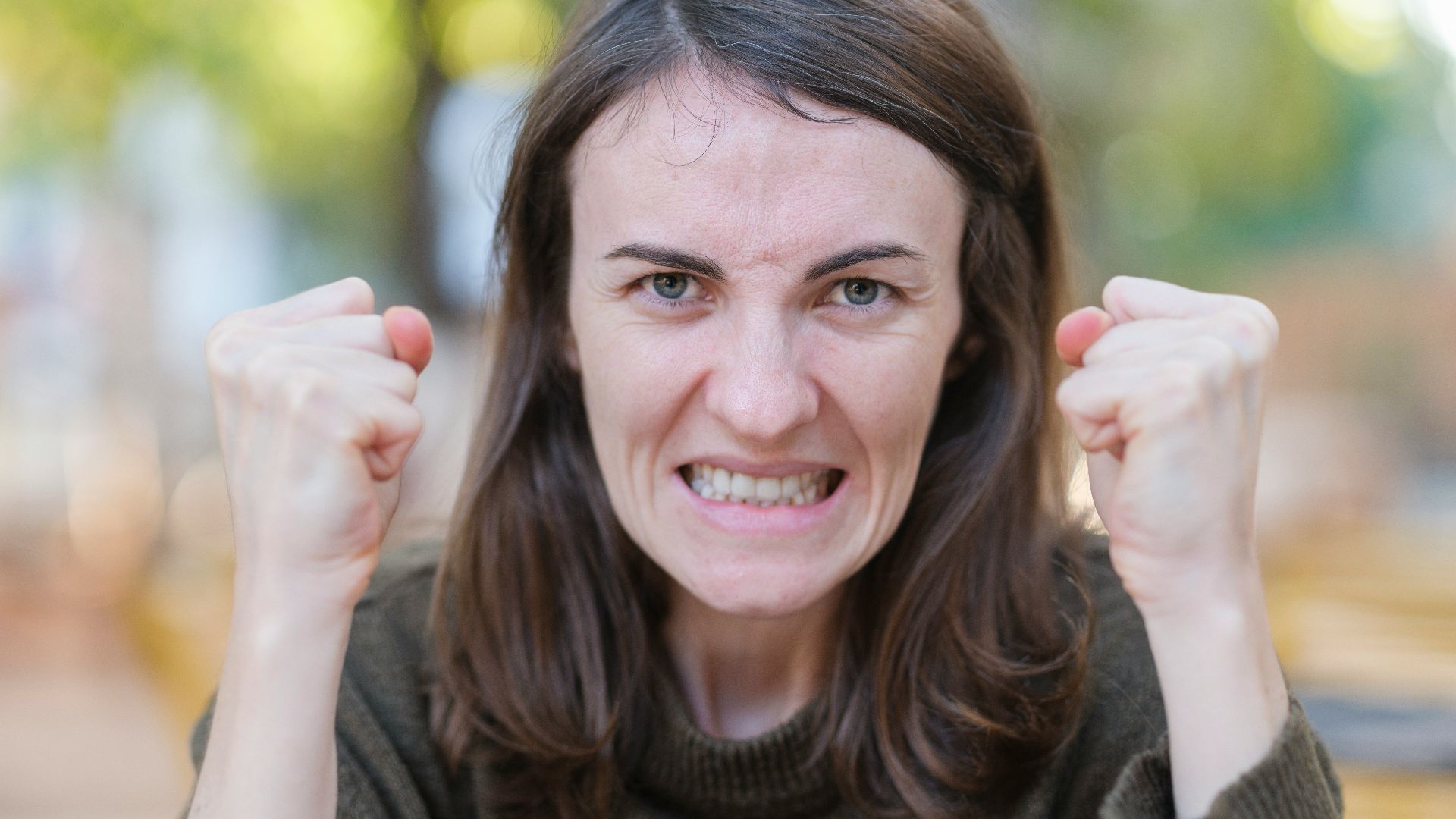 a woman holding her fists up in the air