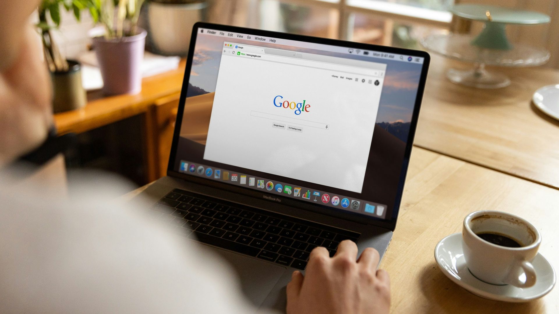 person using macbook pro on table