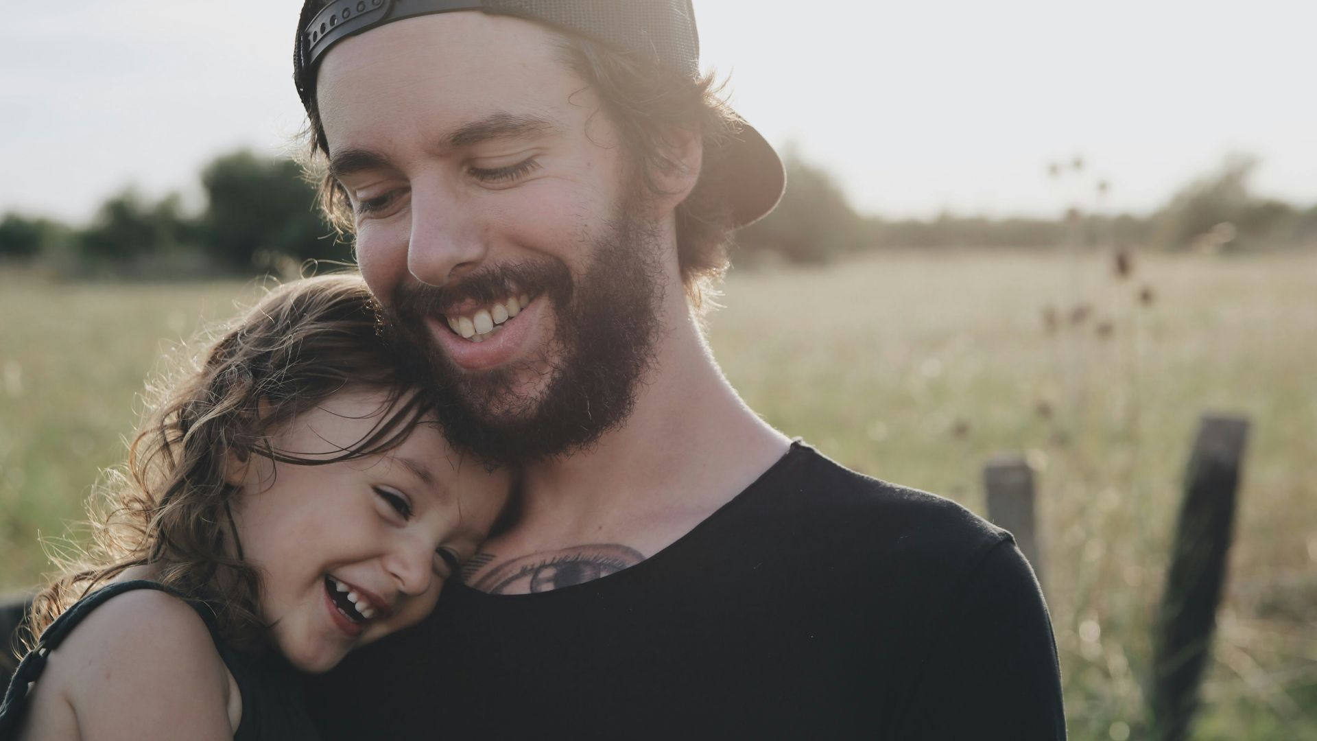man carrying daughter in black sleeveless top