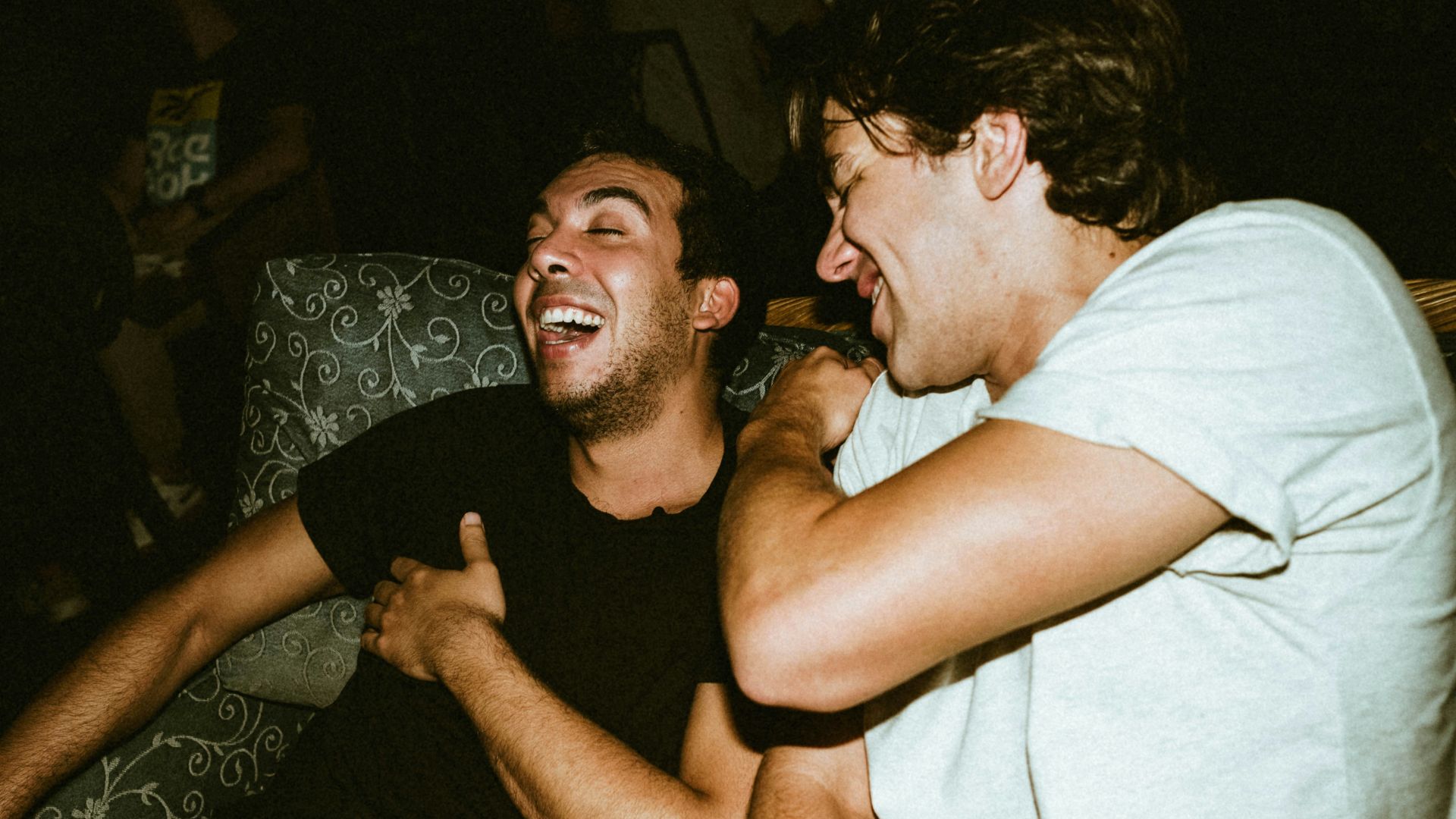 man in white tank top beside man in black crew neck t-shirt