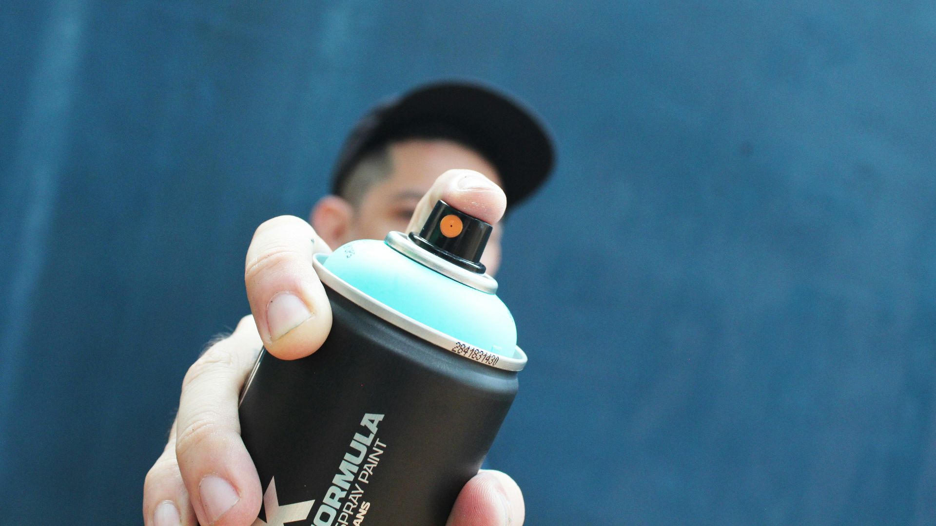a man holding a black and blue spray can