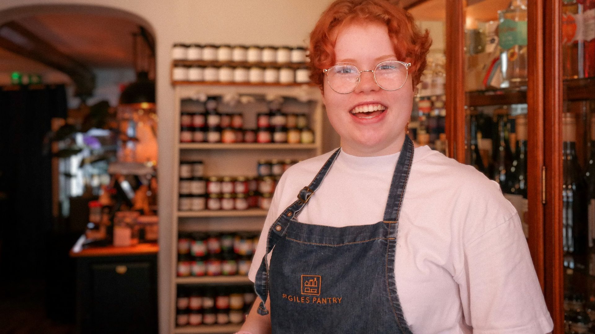 a woman wearing glasses and an apron in a store