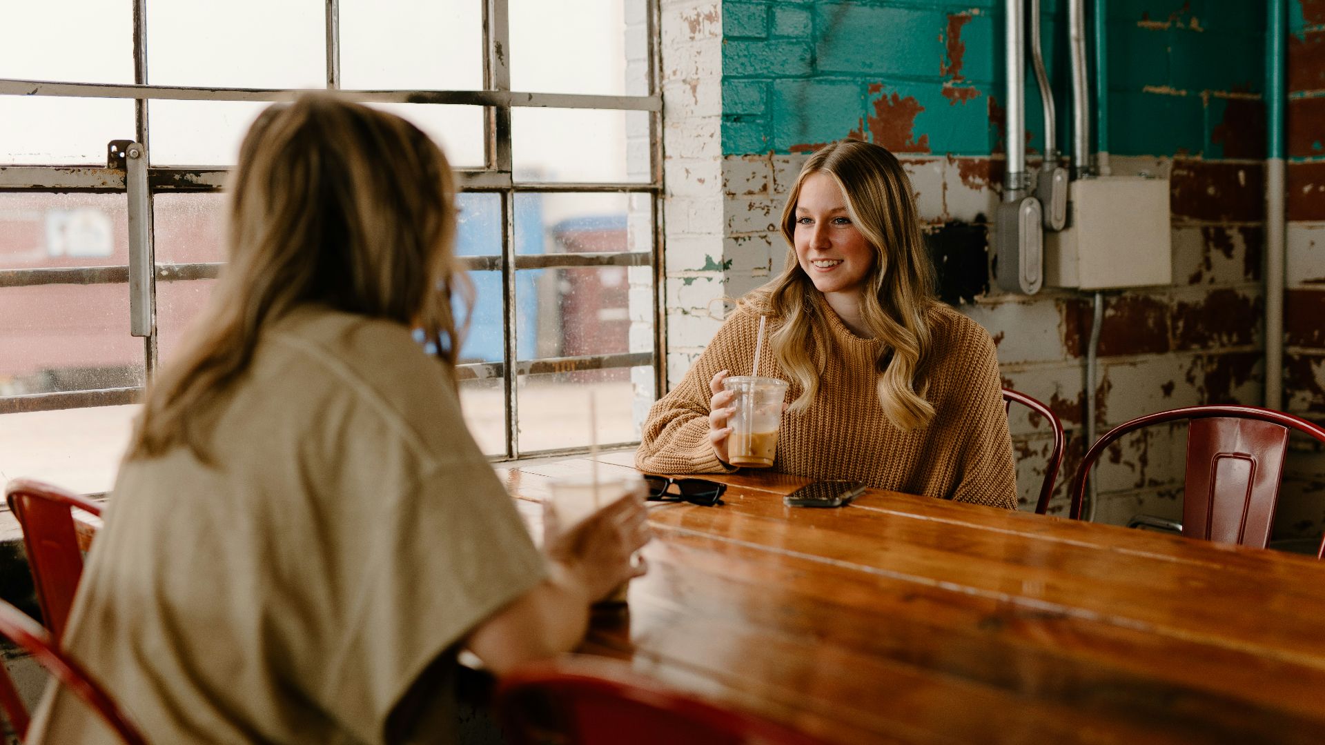 a woman sitting at a table talking to another woman