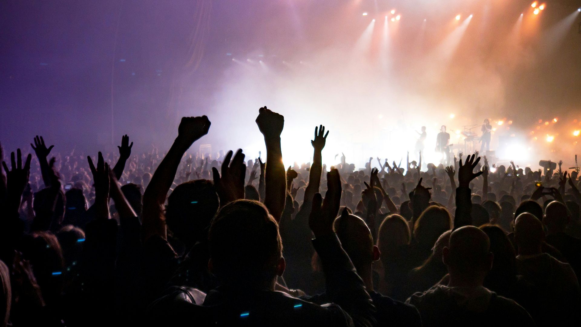 crowd facing lighted stage
