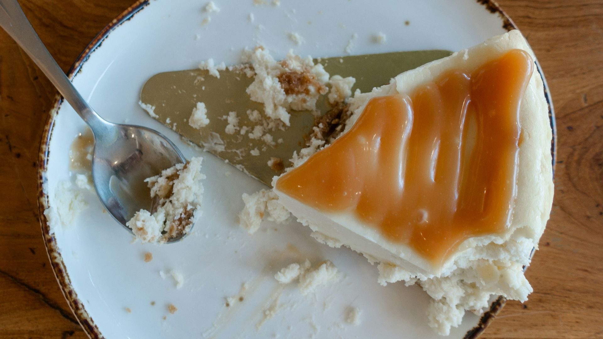 a white plate topped with a piece of cake next to a spoon
