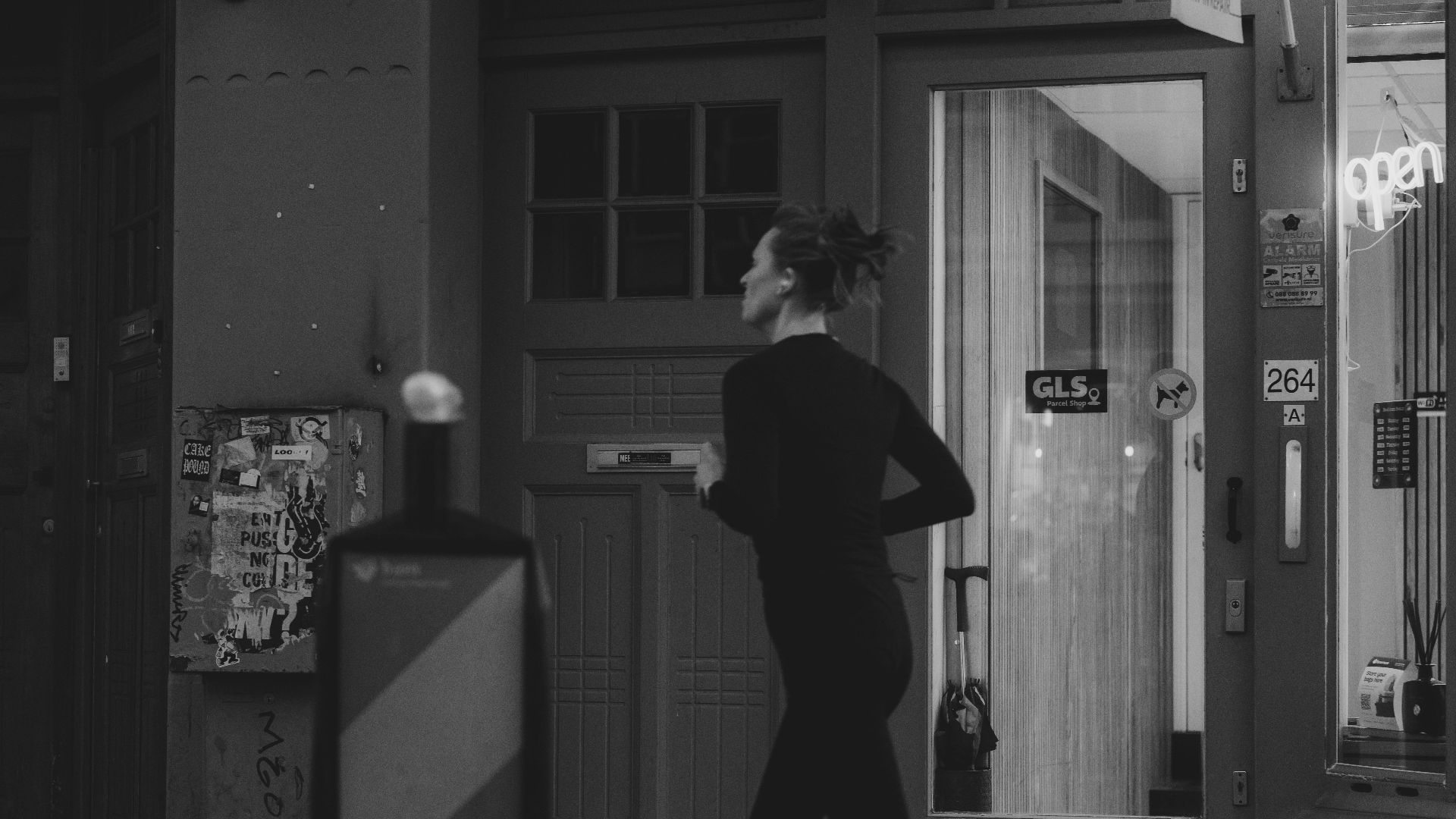 Woman running on city sidewalk at night