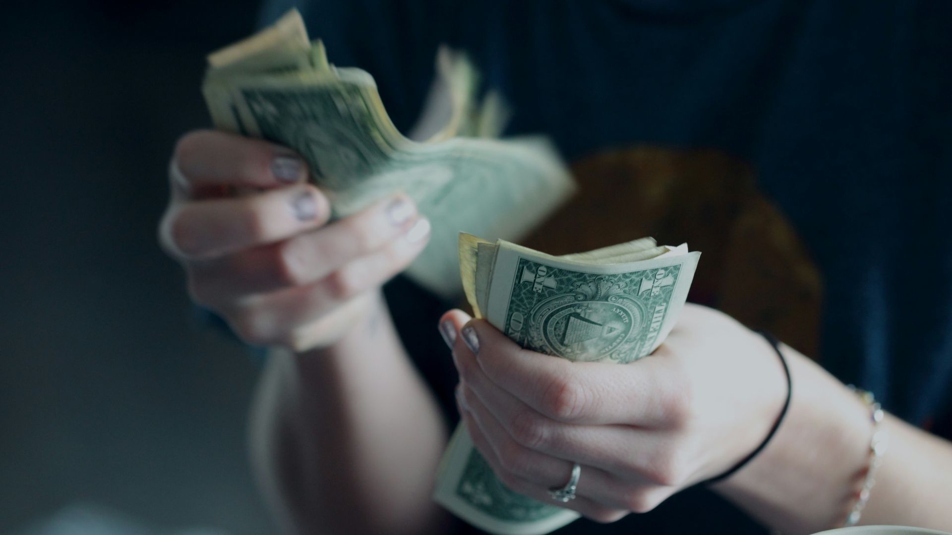 focus photography of person counting dollar banknotes