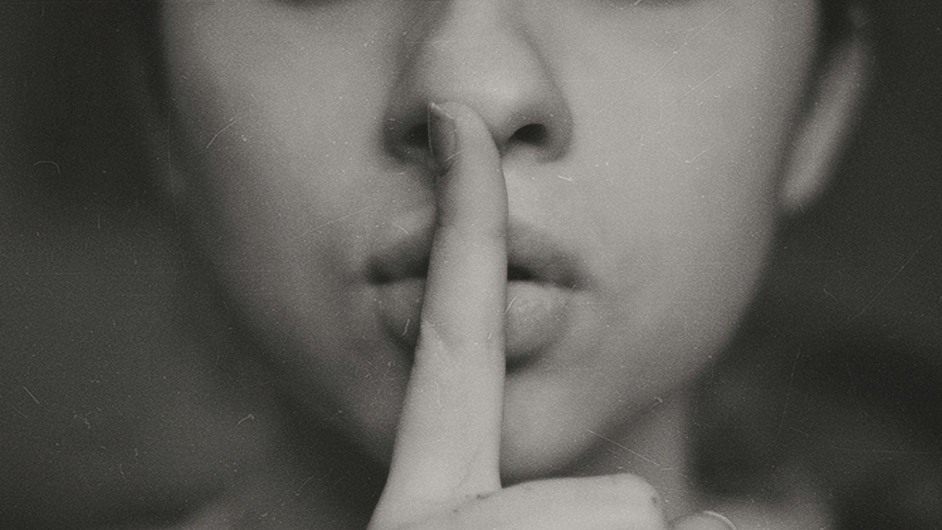 grayscale photo of woman doing silent hand sign