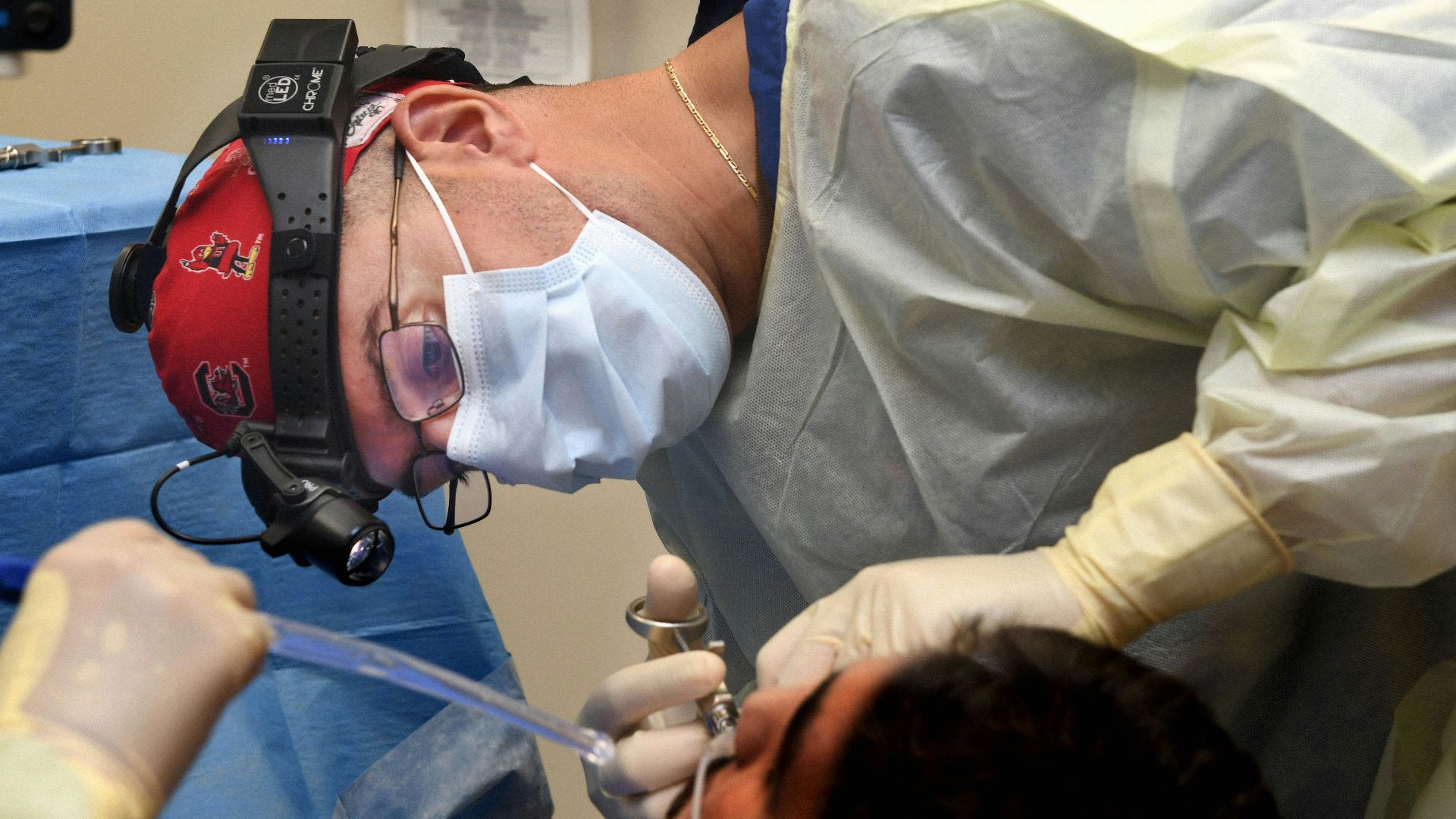 Surgeon performing a medical procedure with instruments.