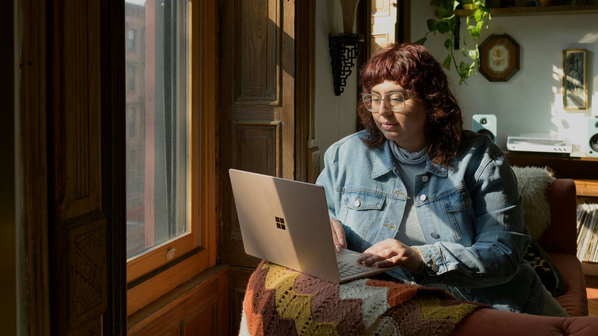 a woman sitting on a couch using a laptop computer
