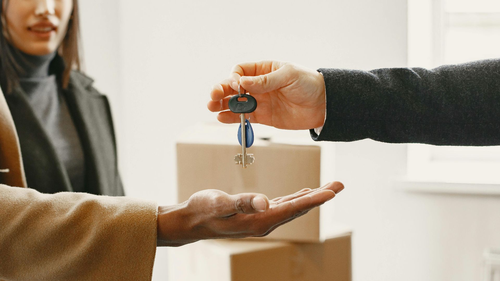 A new homeowner receives keys inside their new home, symbolizing a fresh start.
