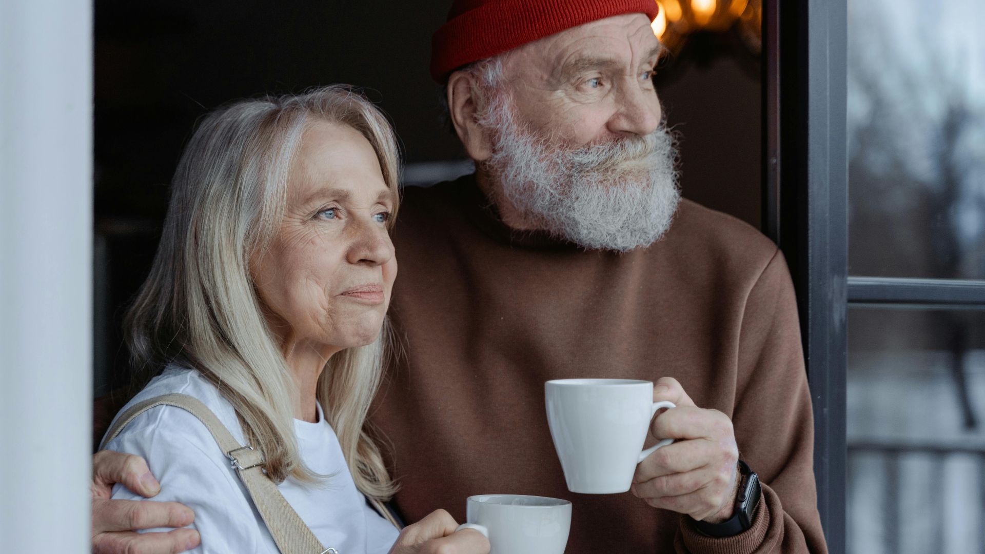 A senior couple embraces while enjoying coffee, symbolizing love and companionship.