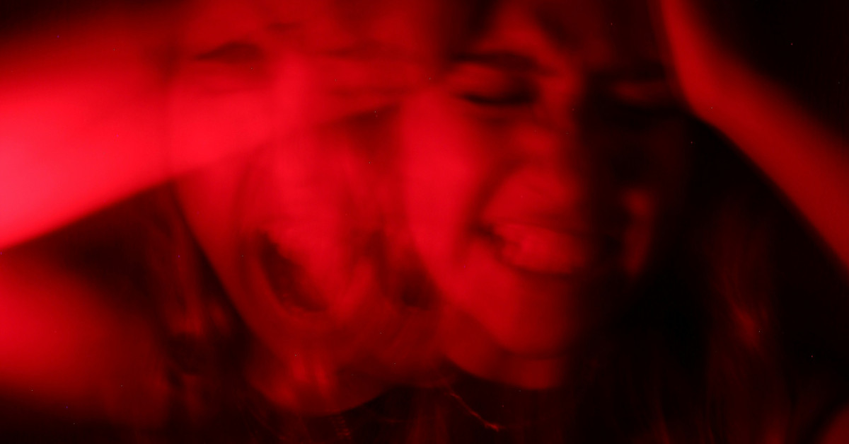 a woman is smiling while holding her hands up