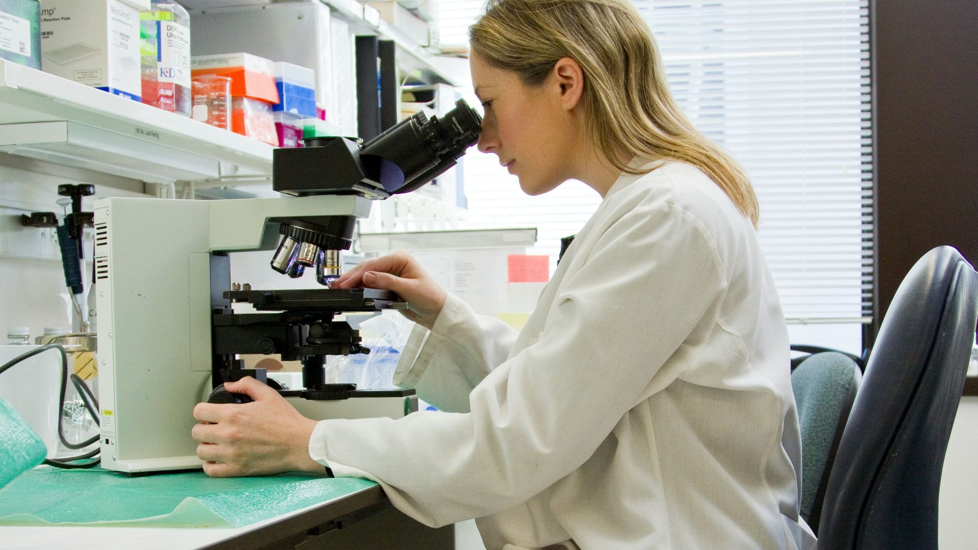 woman in white robe sitting on black office rolling chair