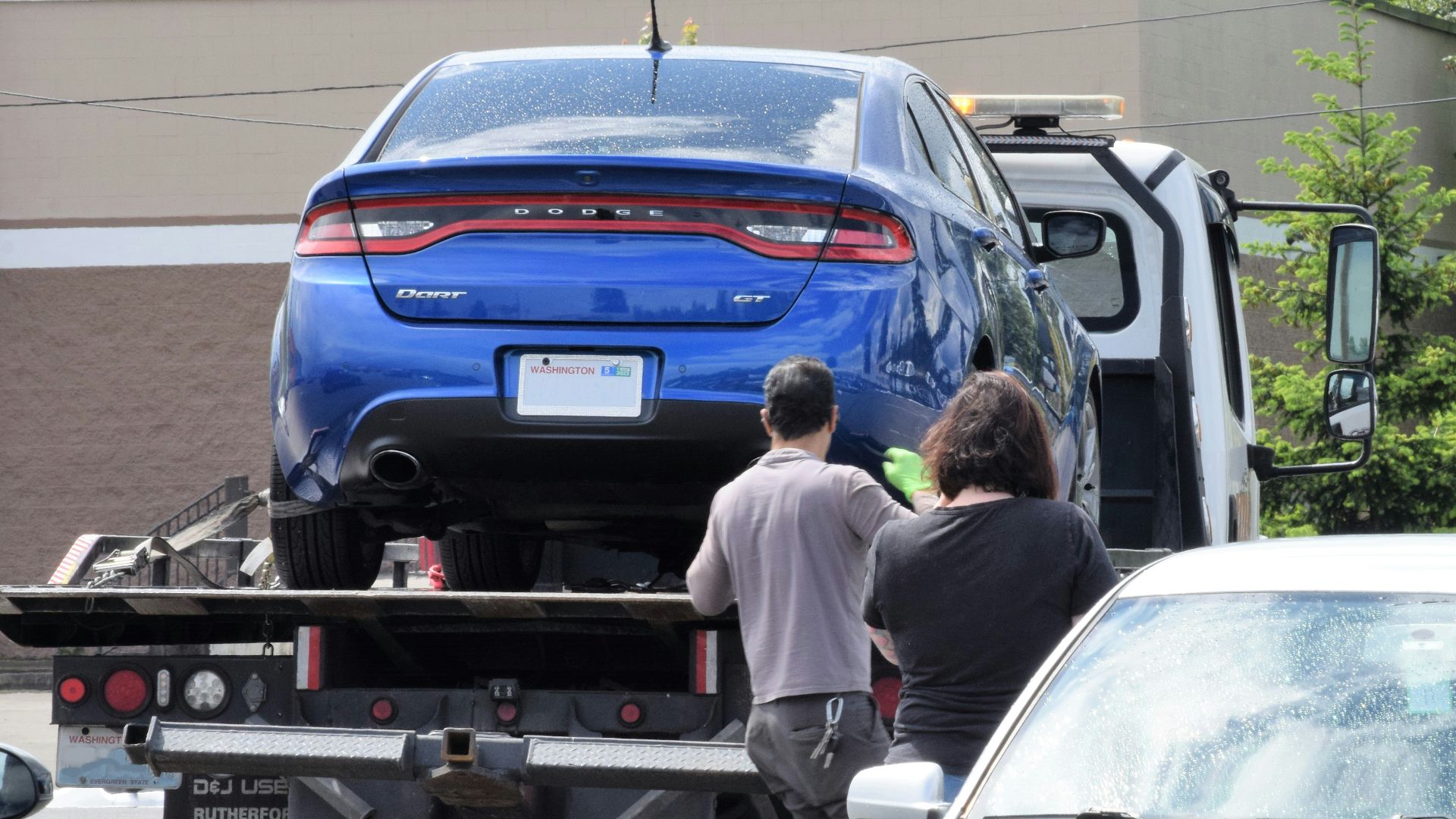 a blue car being loaded onto a flatbed truck